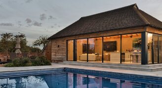 exterior view of a highly glazed pool house with sliding and bifolding doors