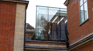 Large frameless glass box extension with glass link to store historical dress collection