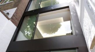 integrated balustrade into sliding glass doors as part of three storey glass extension in London