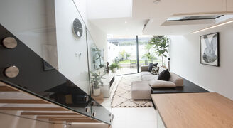 Frameless structural glass balustrades to internal staircase and modern living room