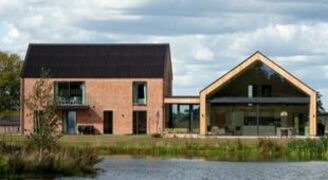 modern two wing farmhouse in Leicester overlooking a lake