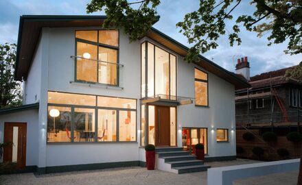 modern windows on white render house shown at night