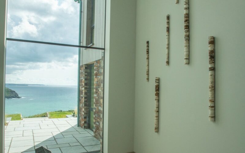 Double height structural glass window to cliffside home