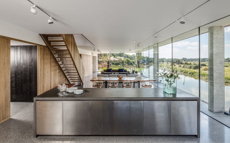 Bright modern kitchen living room offers riverside views through full height glass featured on Grand Designs