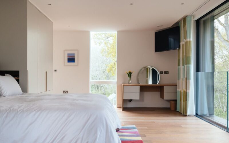 modern Juliet balcony in a contemporary bedroom design with sliding doors and a frameless glass balustrade