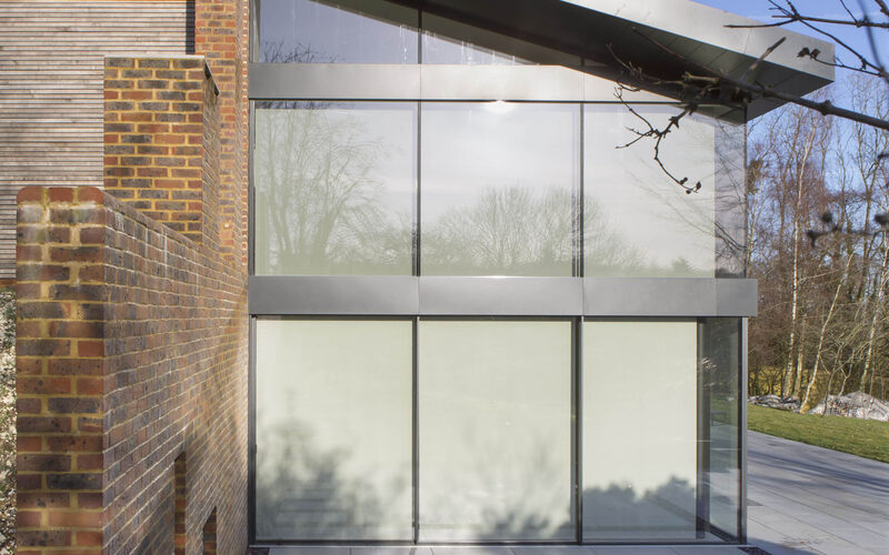 Frameless glass walls and sliding glass facade to new build home