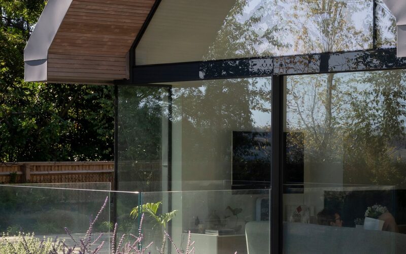 a flush glass window as part of a bespoke gable end window design within timber structure with overhang