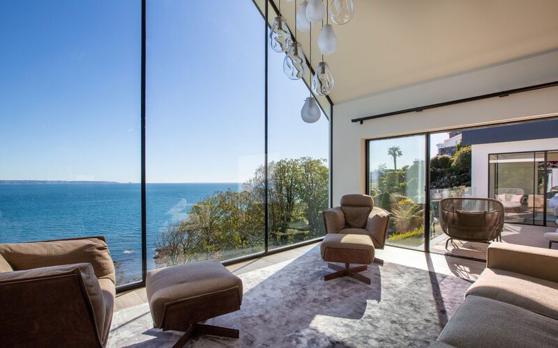 a frameless gable end window overlooking the sea in Guernsey