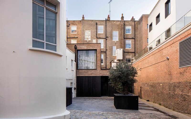 a frameless picture window set into a brick house in London