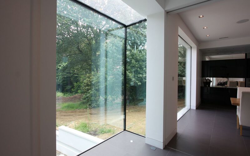 a frameless pop out window within a white plastered wall of a modern house