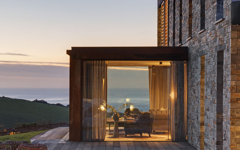 Minimal glass box extension to Cornish slate new build home