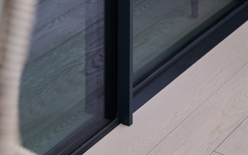 close up image of flush threshold door meeting decking