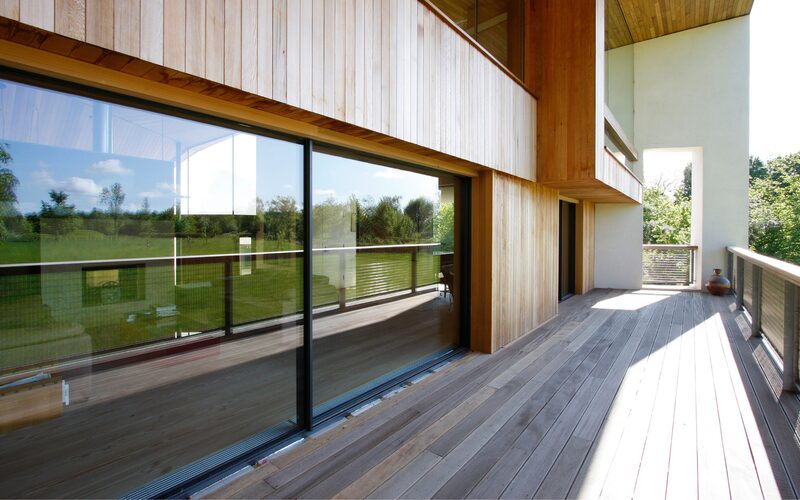 large glass sliding doors set into a timber wall leading to a balcony