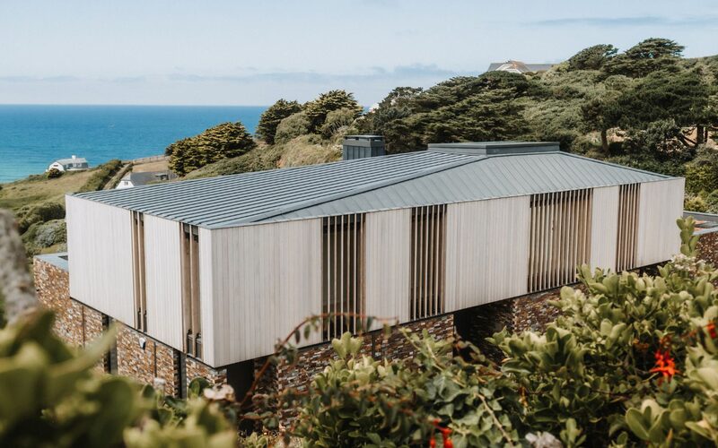 house with hidden windows on cliff overlooking the sea in cornwall