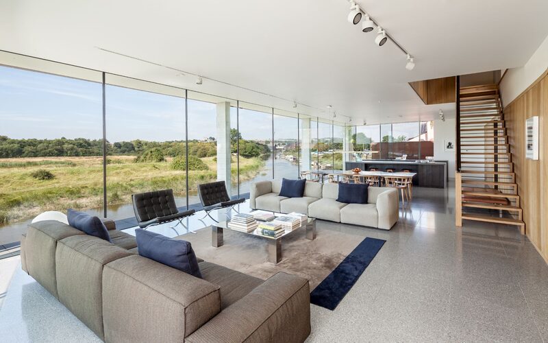 Modern lounge with frameless glass offers stunning riverside views.