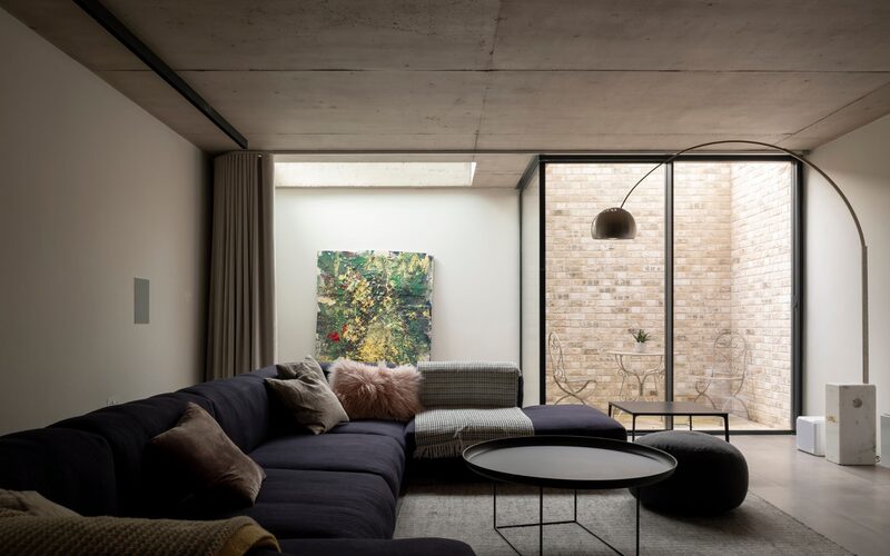 a glass courtyard in a basement with sliding glass doors