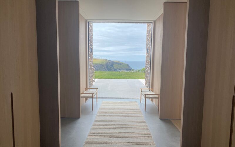 frameless-window-overlooking-cliffs-mawgan-porth-cornwall-green-hedges