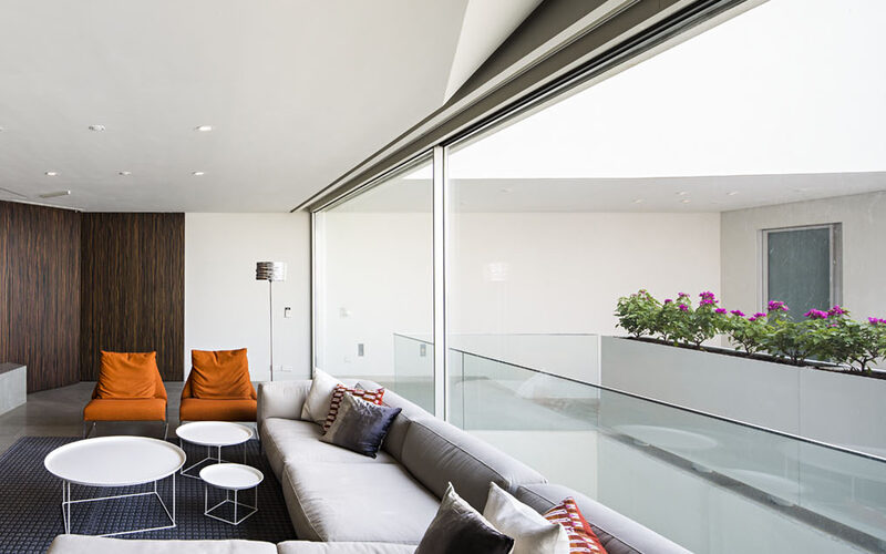 Slim sliding glass doors leading onto glass balcony