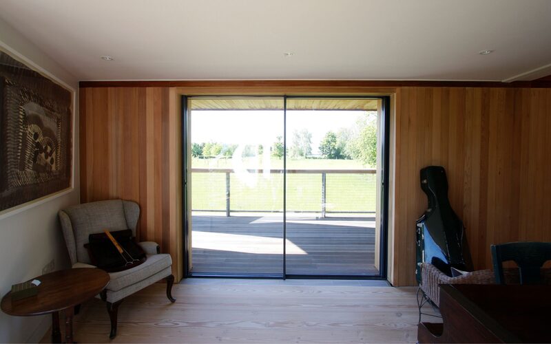 slim glass sliding door set into timber wall as part of a sustainable build