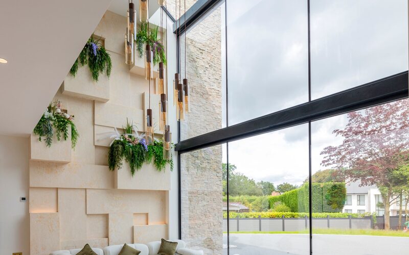 A beautiful aspect through double height glass which creates an atrium into the living space in Little Aston luxury home.