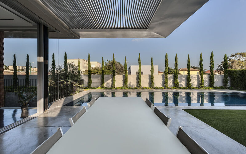 Aluminium louvre roof overhanging poolside patio area accessed via slim sliding glass doors