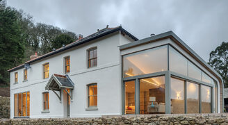 Minimal glass box extension with structural glass and sliding glass doors