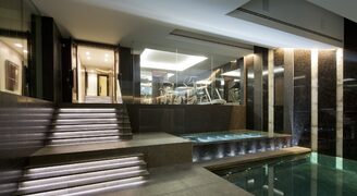 Internal basement swimming pool with heated glass walls and balustrades