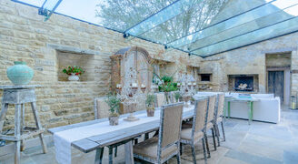 large frameless glass roof with glass beams to rustic garden extension