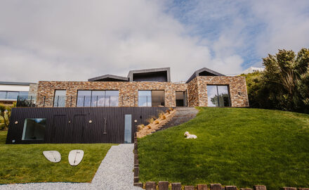 Glazed facade of sliding glass doors on Cornish home