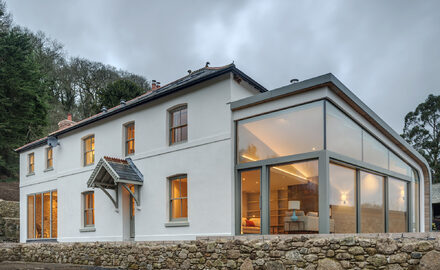 Minimal glass box extension with structural glass and sliding glass doors